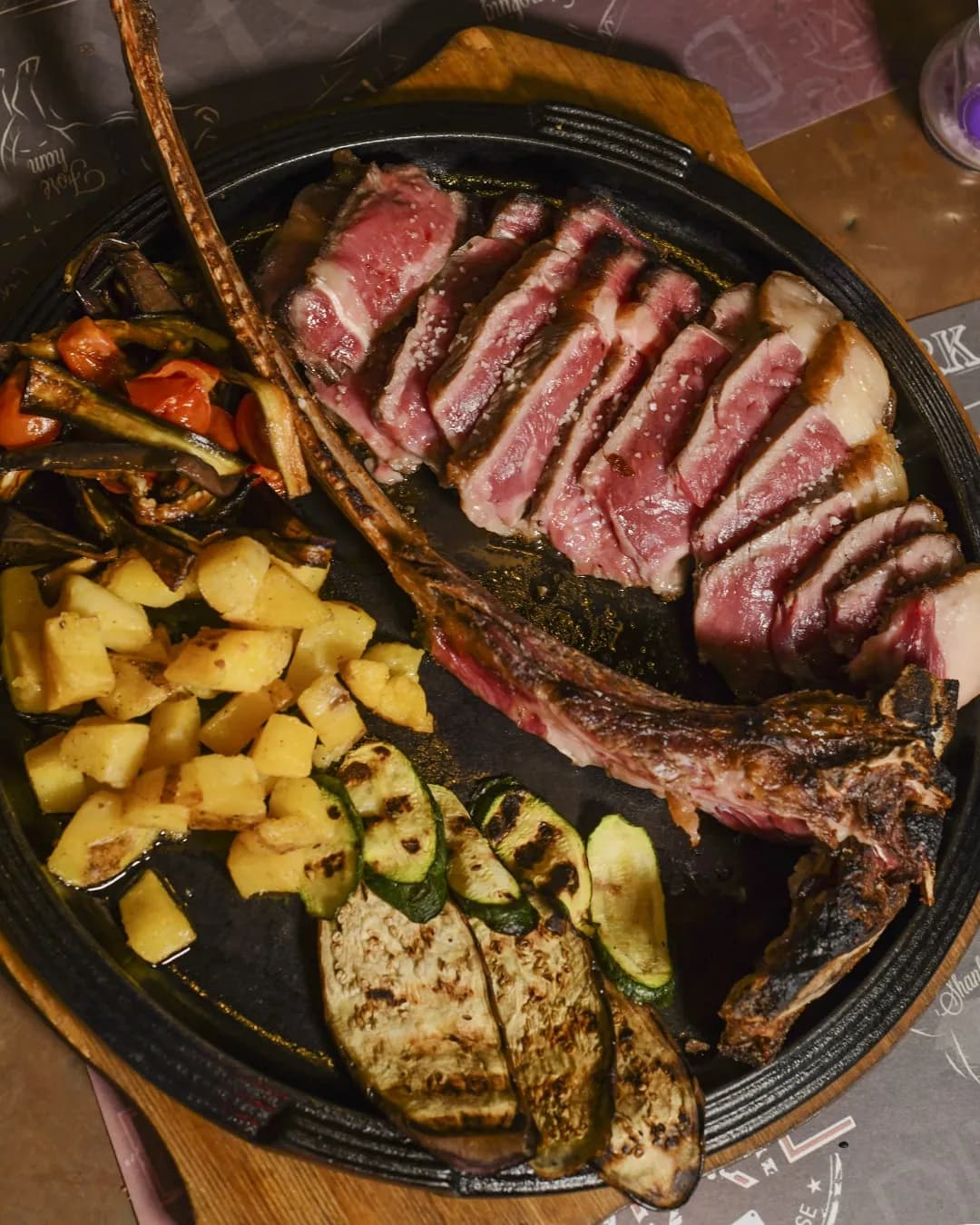 Tomahawk di bovino con l'osso lungo servito su tagliere